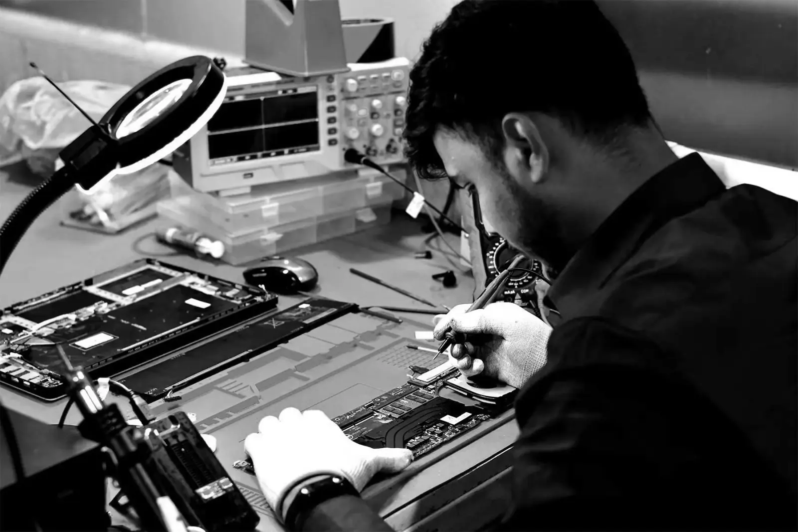 SPURGE technician repairing a laptop at the service bench